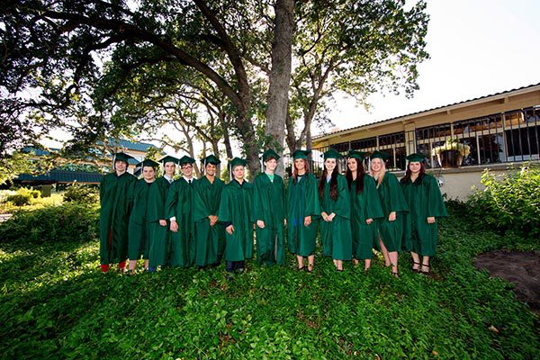 High school graduates wearing green caps and gowns