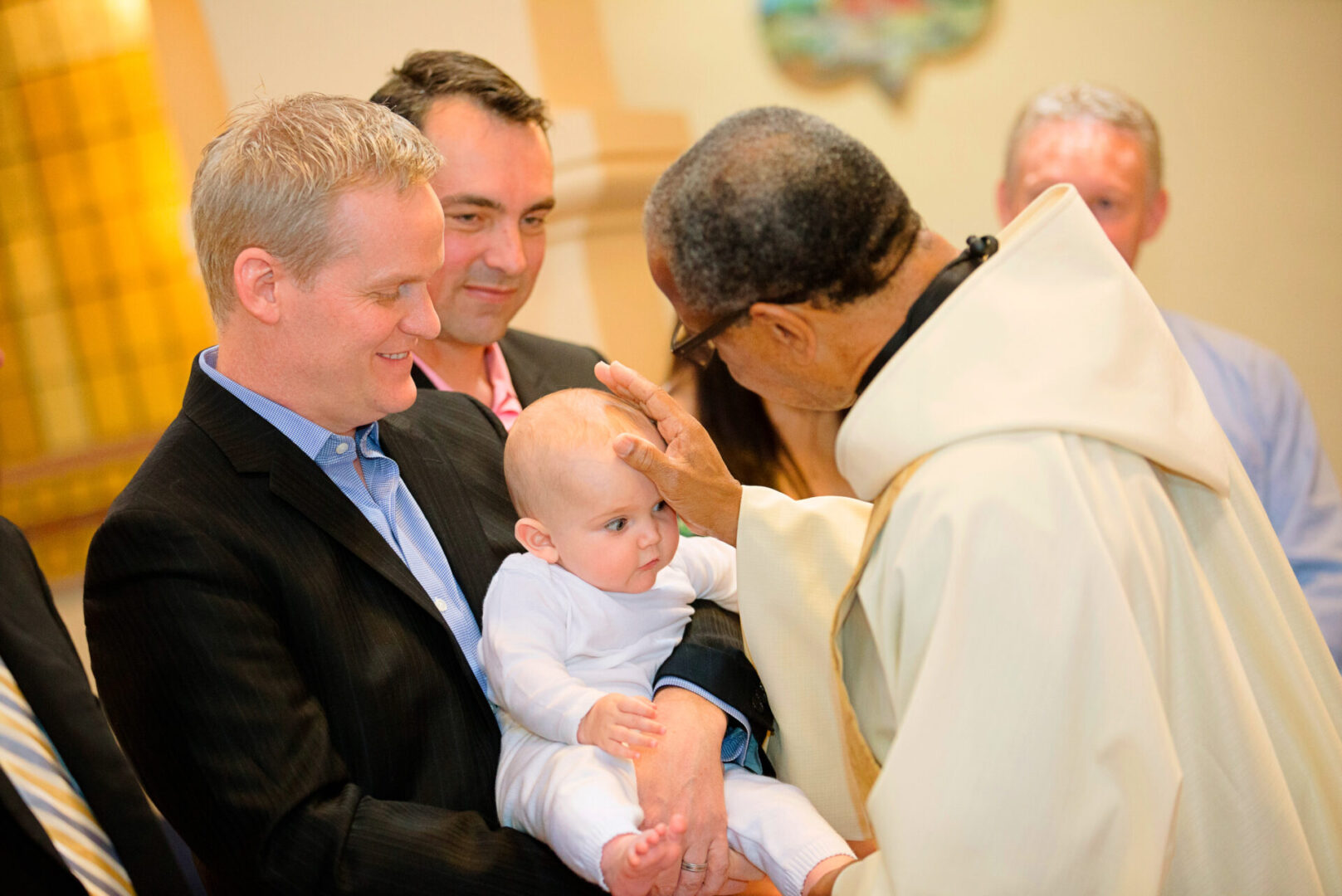 A priest touching a baby