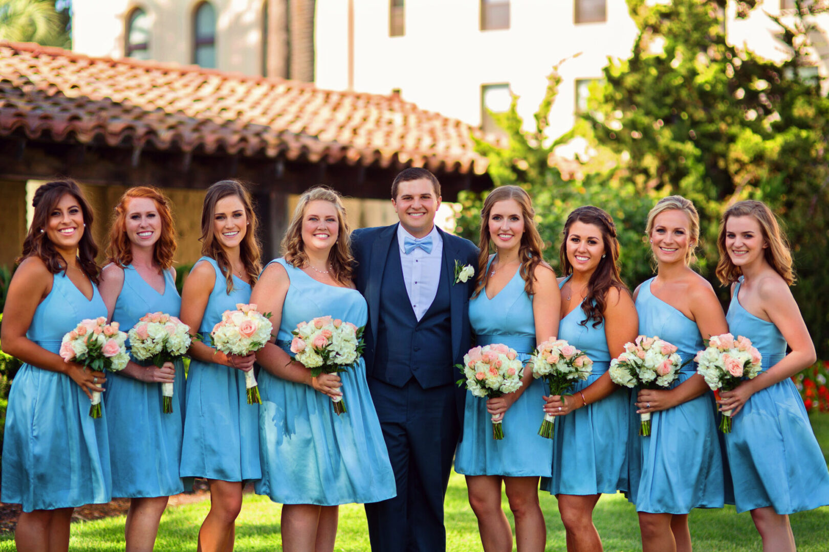 A groom standing with some ladies