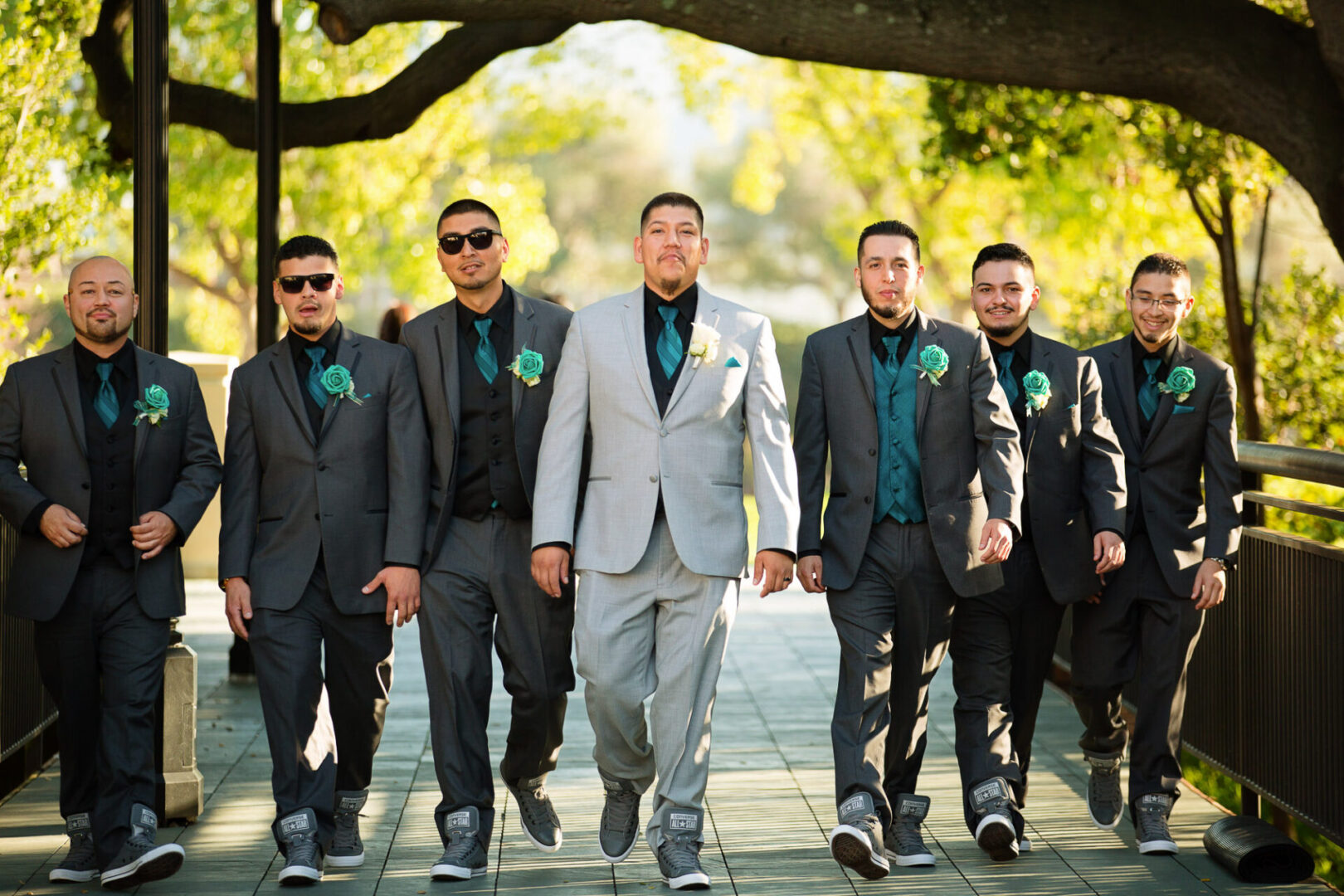 A groom walking with some boys wearing the same dress
