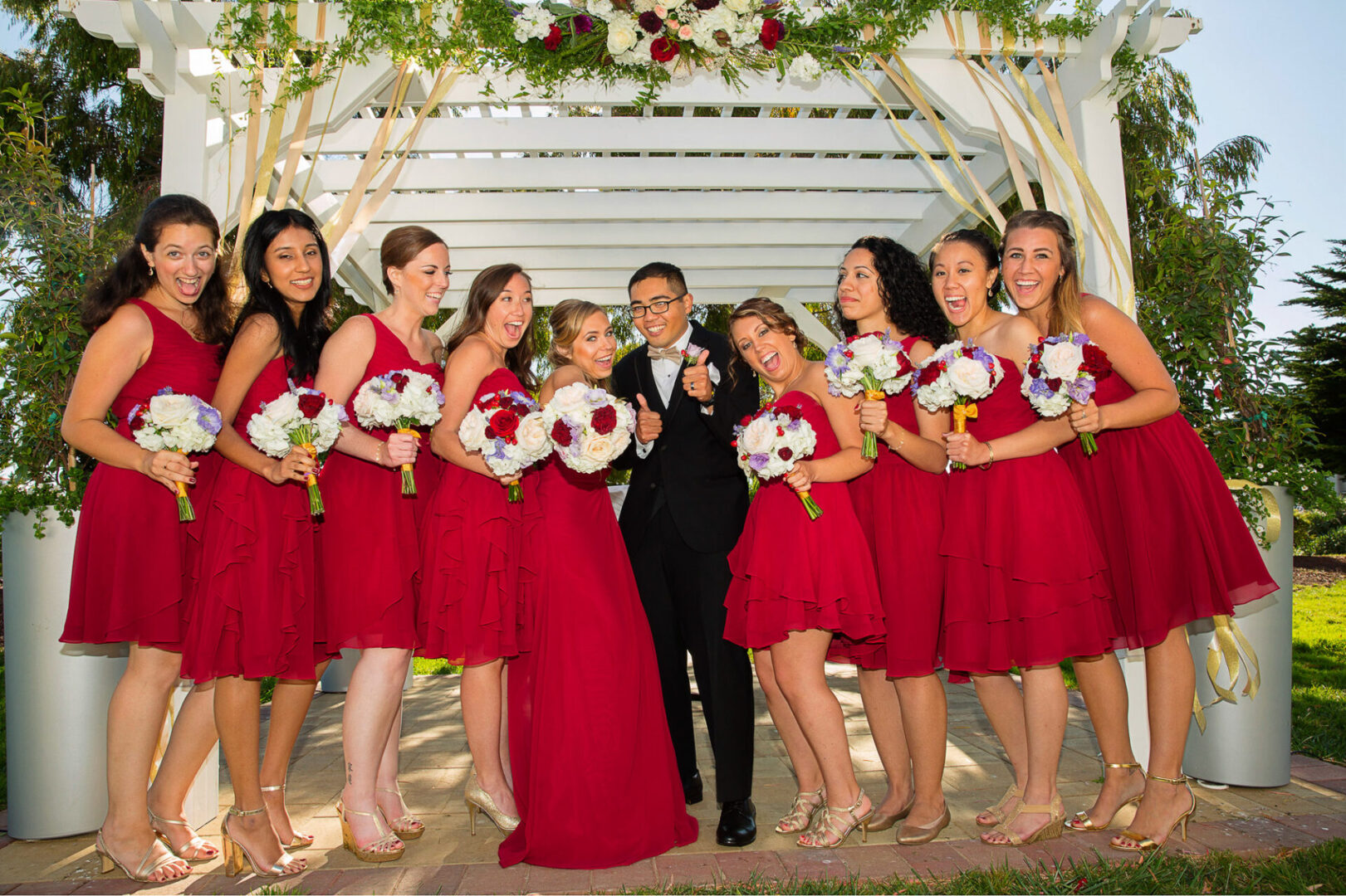 A couple standing with so many girls in red dress