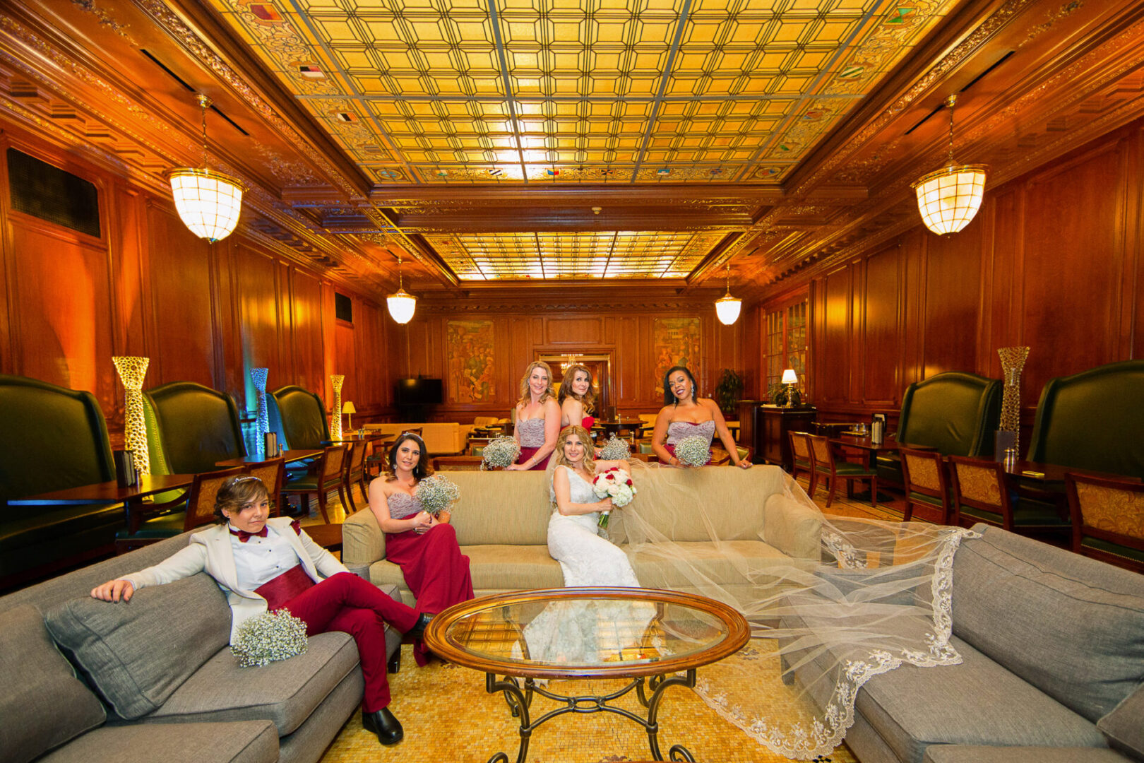 A bride sitting on a couch along with other girls