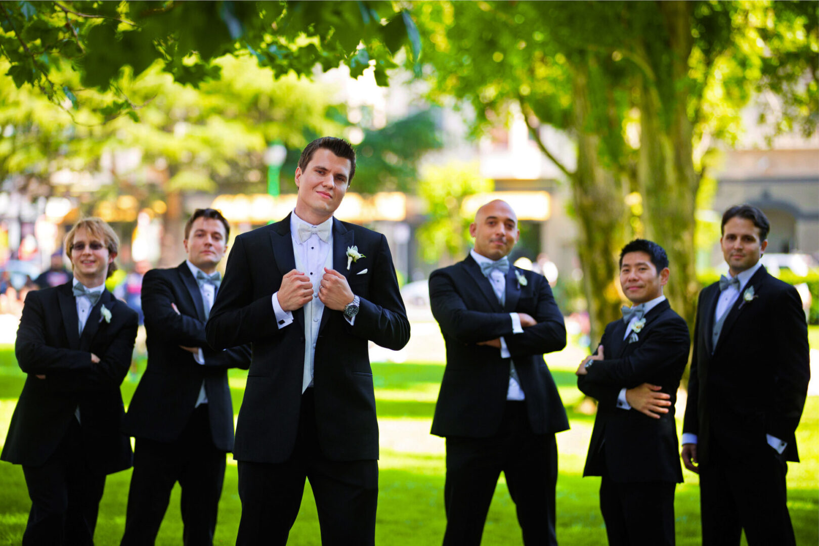 A groom standing with some other peoples in a field