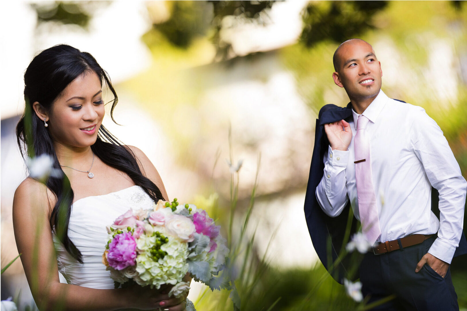 A bride holding flowers in hand with groom