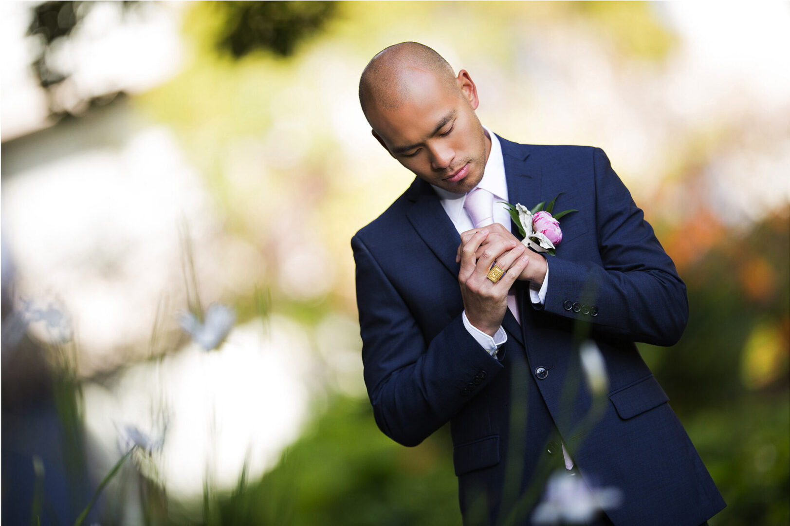 A handsome groom wearing a suit posing at the camera