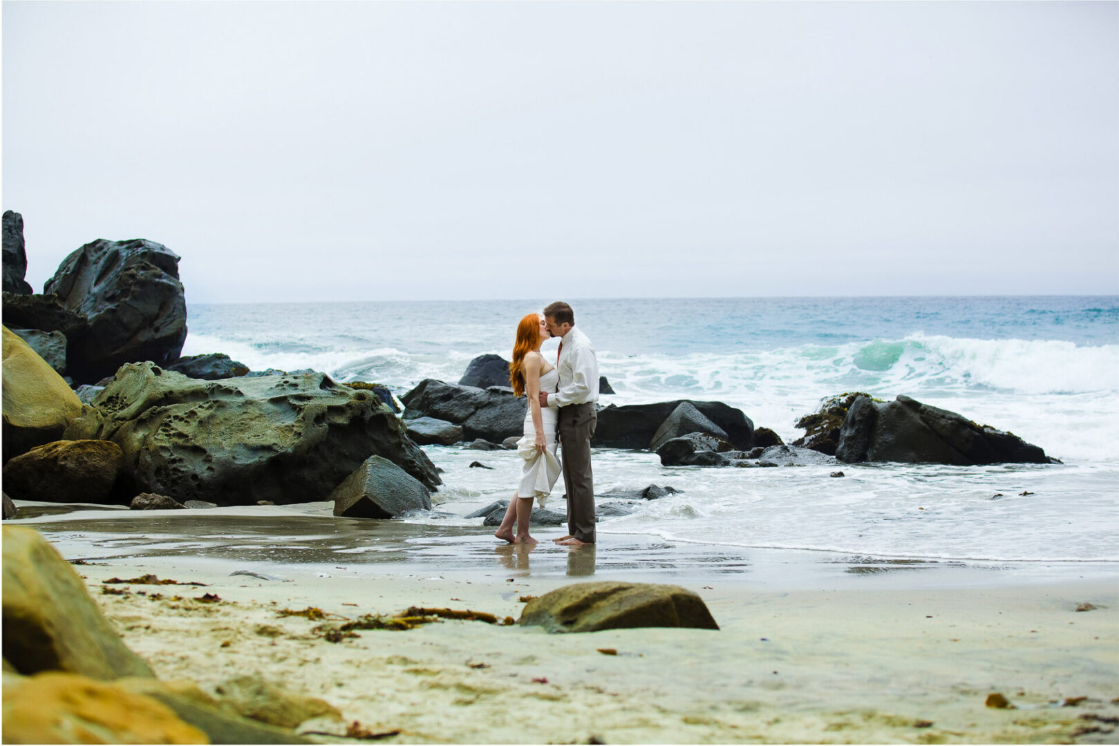 Bride and groom kissing each other on a beach