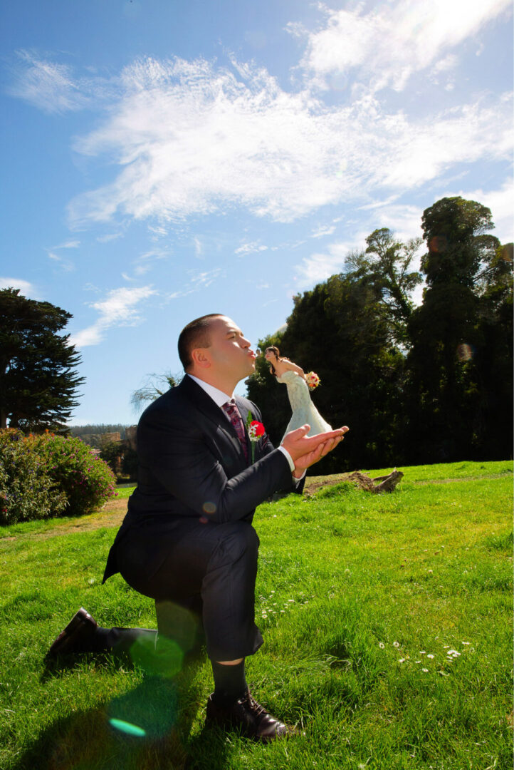A man kissing a bride standing on his hand