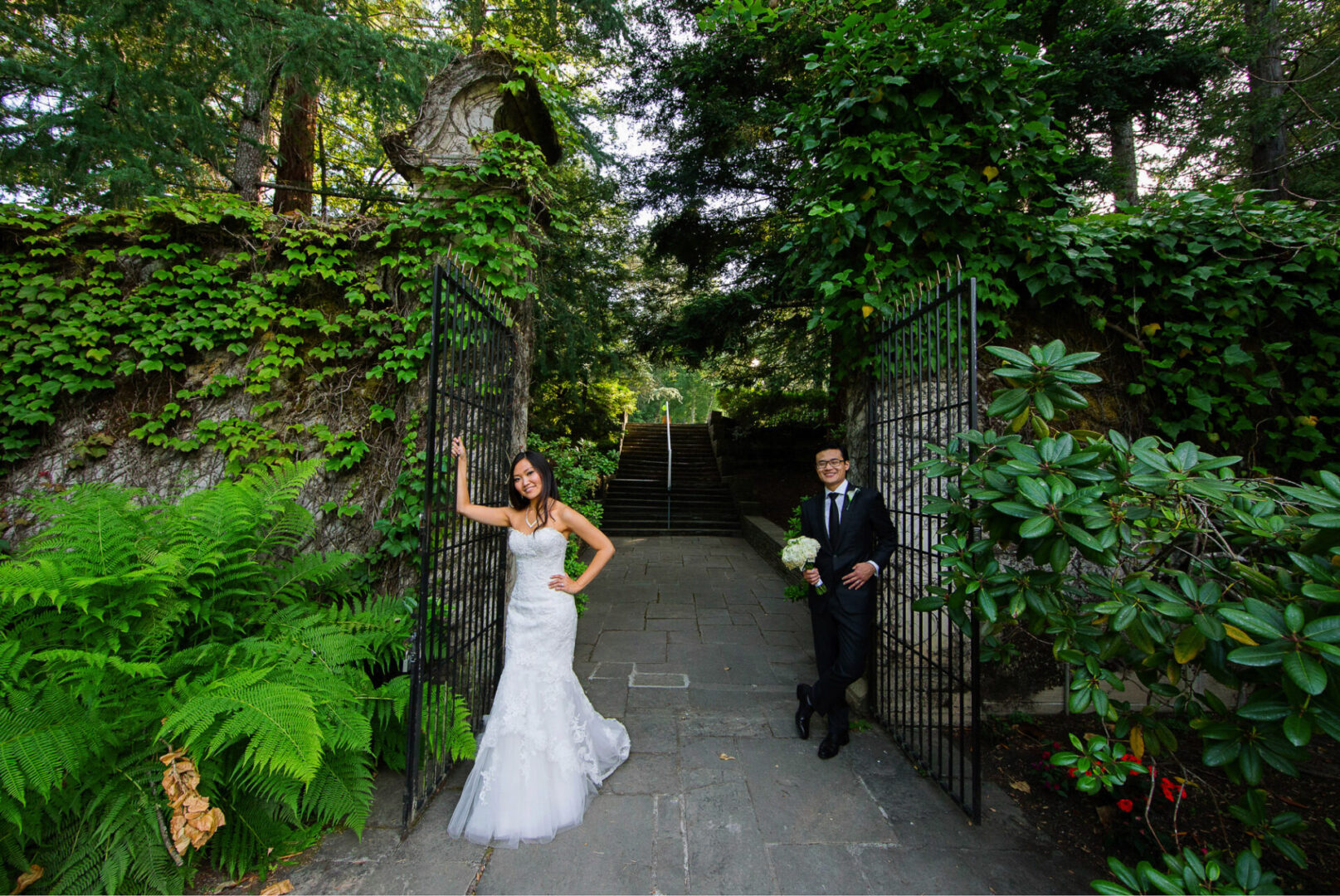 A newly married couple standing near a gate