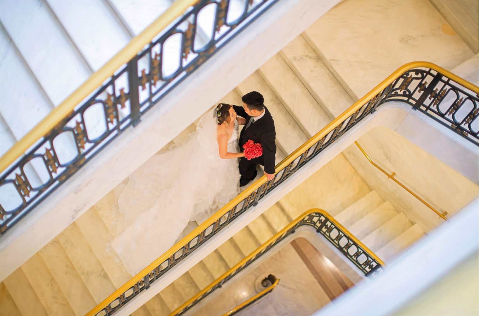 A newly married couple posing on the stairs